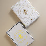 top view of the lid and tray of the gold foiled golden wildlife oracle box, with the cover of the guidebook showing in the tray. 