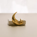a close-up view of a white matte ceramic oracle card holder with a sculpted moon and star.