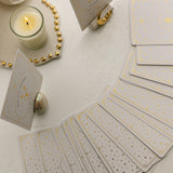 a pearlescent ceramic oracle card holder displaying the horse card from the golden wildlife oracle with a burning candle, ritual shelf, celestial card stand and face down cards from the deck nearby.